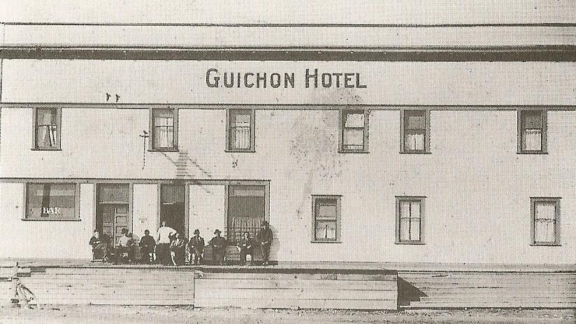 The Guichon Hotel with guests gathered on the front porch